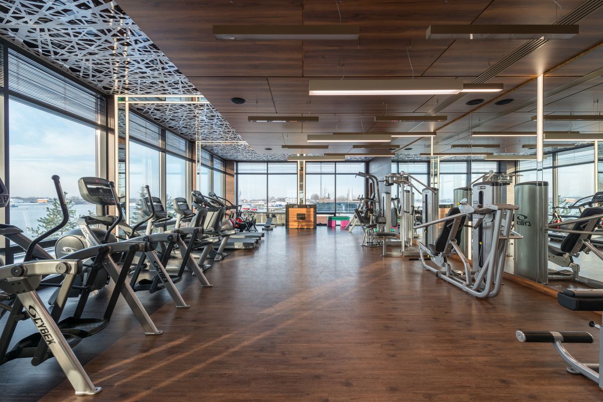Laufbänder und Geräte in einem hellen Fitnessraum mit Panoramafenstern