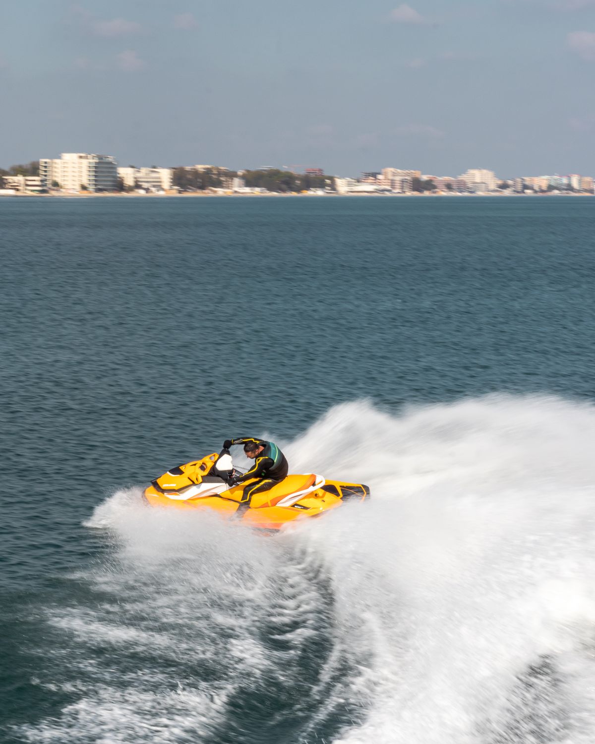 Jetski in voller Fahrt mit Gischt auf türkisem Wasser